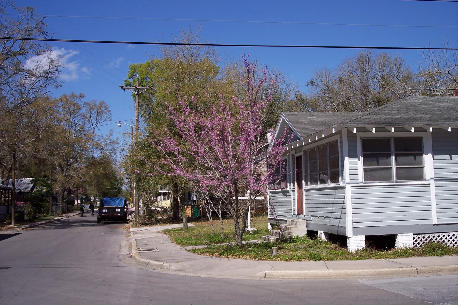 White wood-frame bungalow with a screened porch on a corner lot in the Pleasant Street Historic District of Gainesville