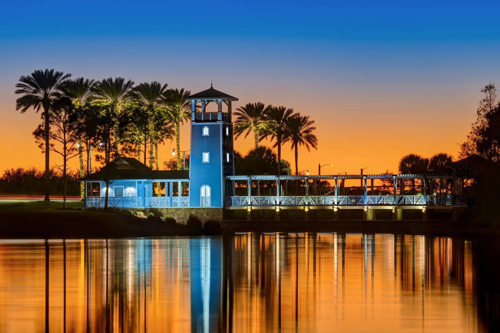 Lighted tower and boardwalk on Lake Tradition in Port St. Lucie at twilight