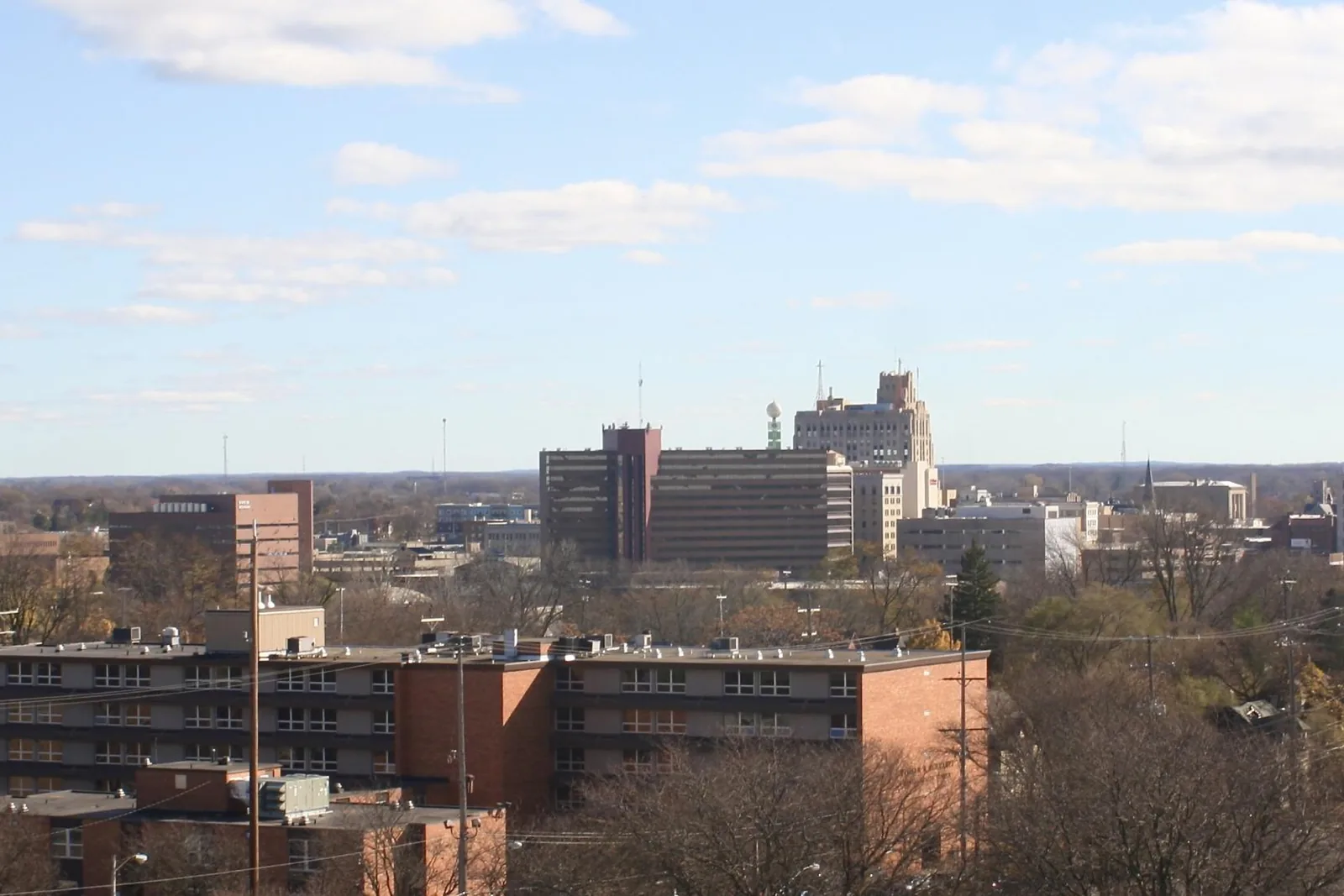 Downtown Flint skyline seen from the south on a clear autumn day, with brick apartment blocks in the foreground