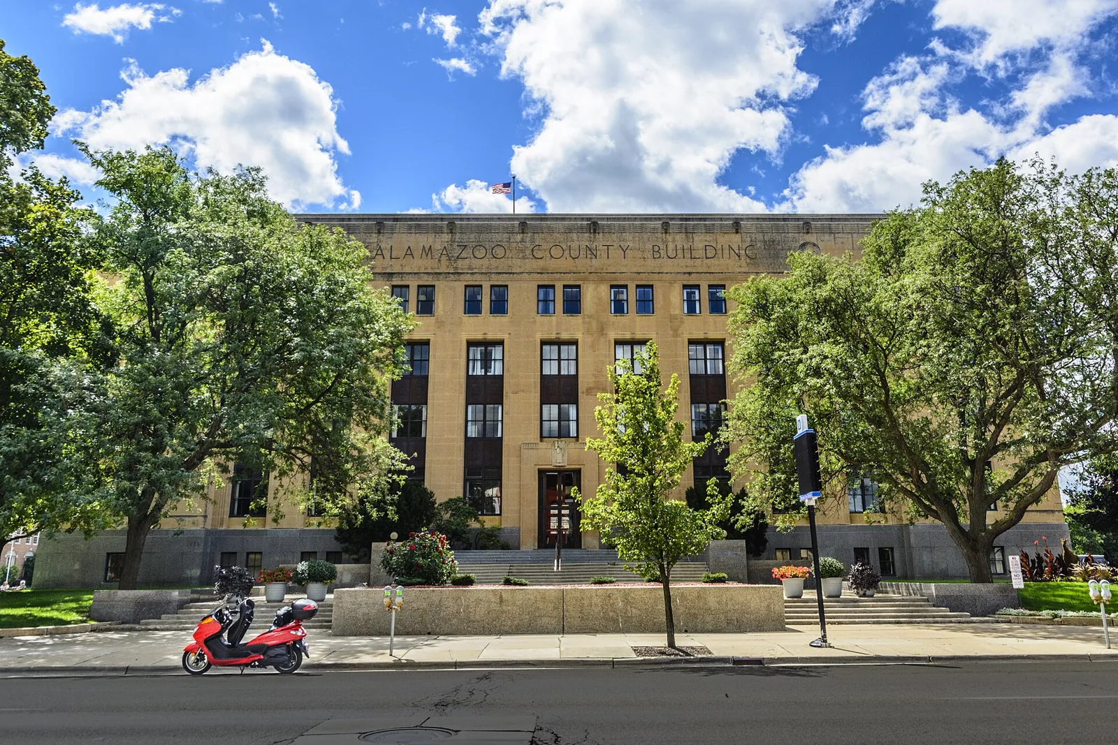 The Art Deco Kalamazoo County Building on a sunny day, framed by street trees