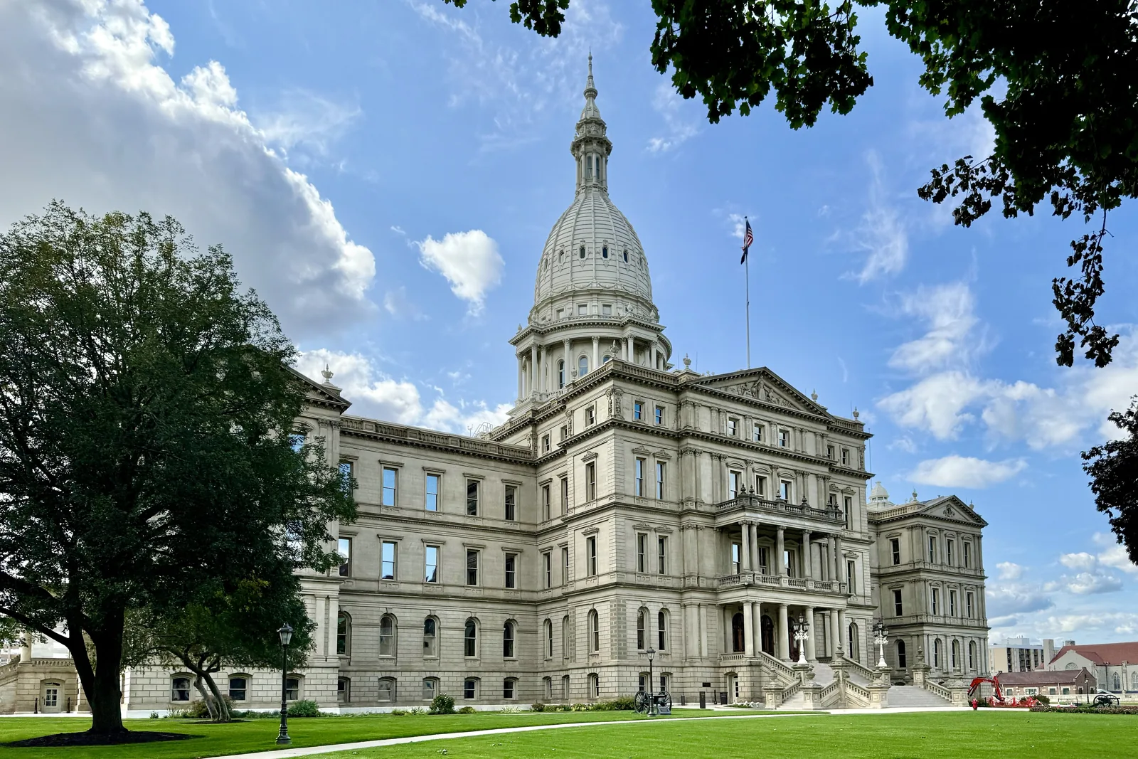 The Michigan State Capitol dome and east front on Capitol Avenue in downtown Lansing under a blue sky