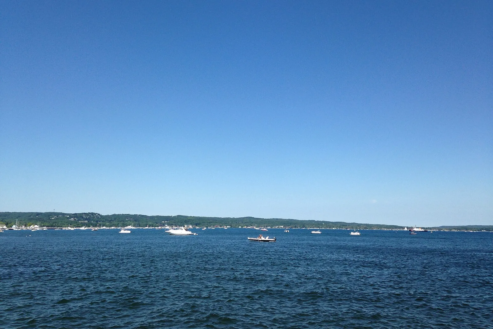 West Grand Traverse Bay on a clear summer day, with boats on the water and the Traverse City shoreline in the distance