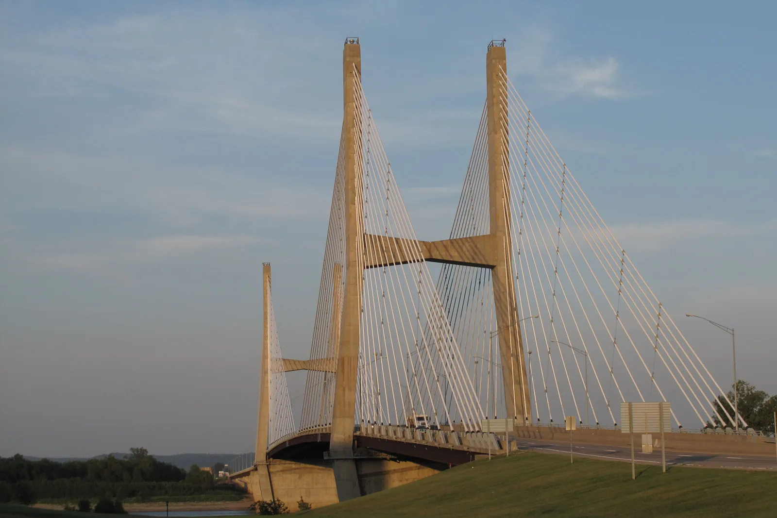 The Bill Emerson Memorial Bridge in Cape Girardeau, its two concrete towers and white cables rising over the Mississippi River at sunset