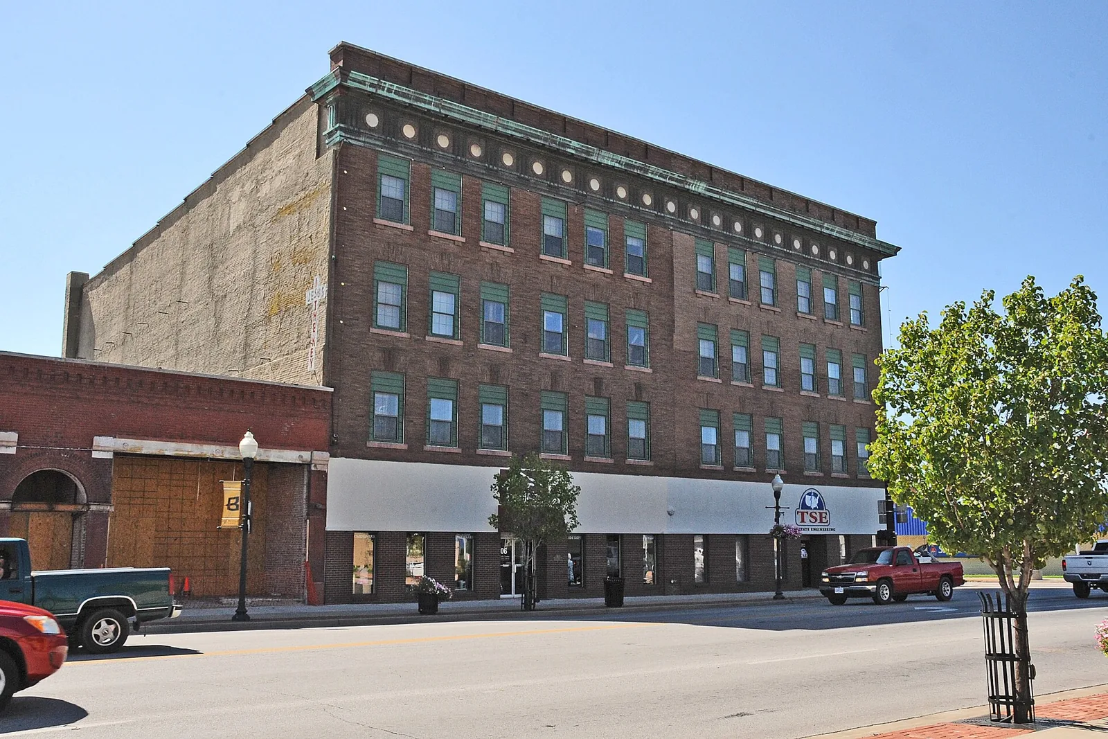 Four-story brick commercial building with green trim on Main Street in the Main and Eighth Street Historic District, Joplin, Missouri.