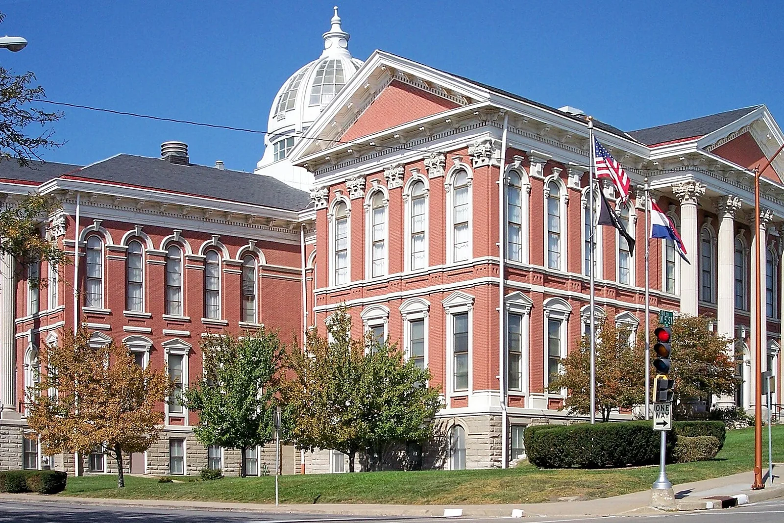 Red-brick Buchanan County Courthouse with a white dome and flags in St. Joseph, Missouri, on a sunny day.