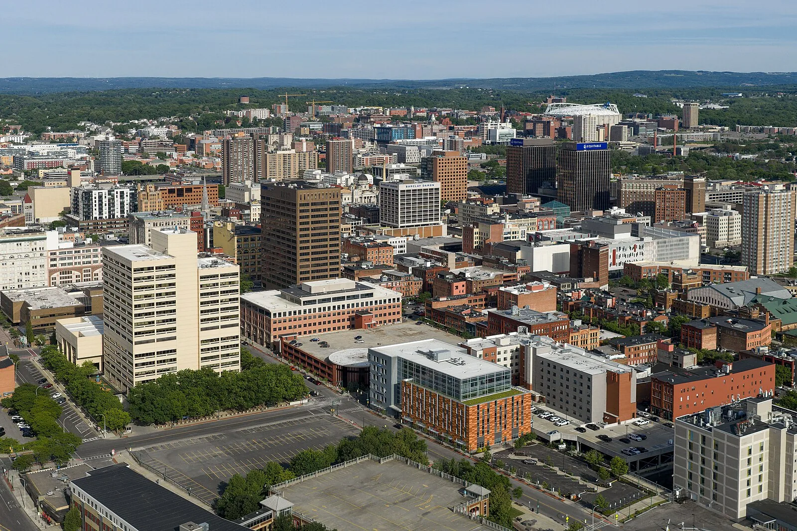 Downtown Syracuse seen from the air on a summer day, with the university hill beyond