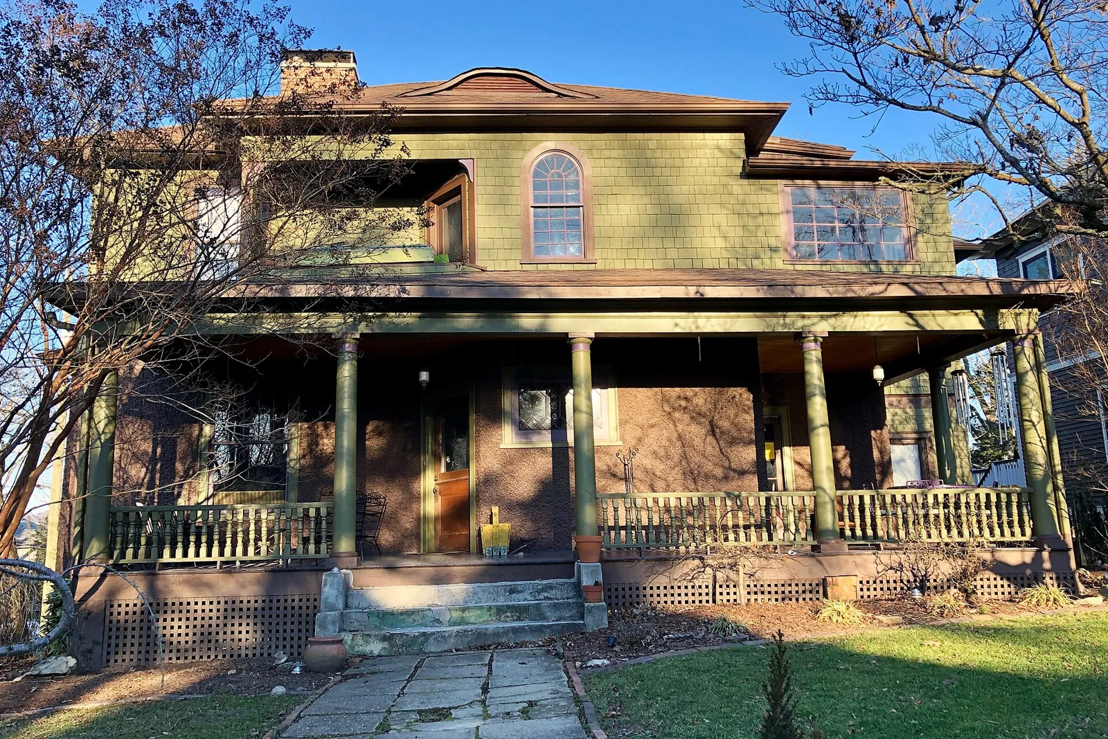 A two-story shingled house with a deep front porch on Montford Avenue in Asheville, North Carolina