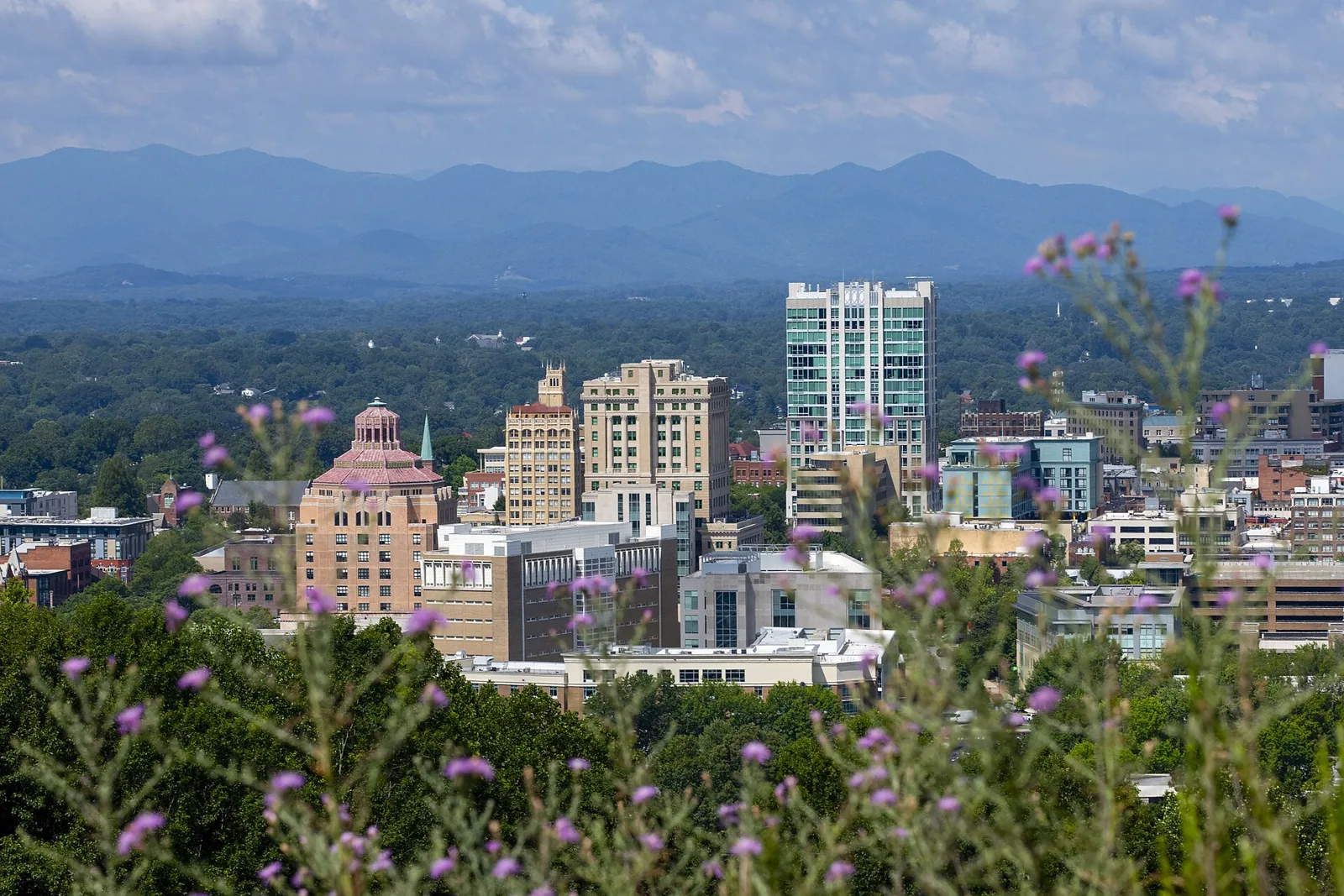 Downtown Asheville, North Carolina, with the Blue Ridge Mountains behind it on a summer day