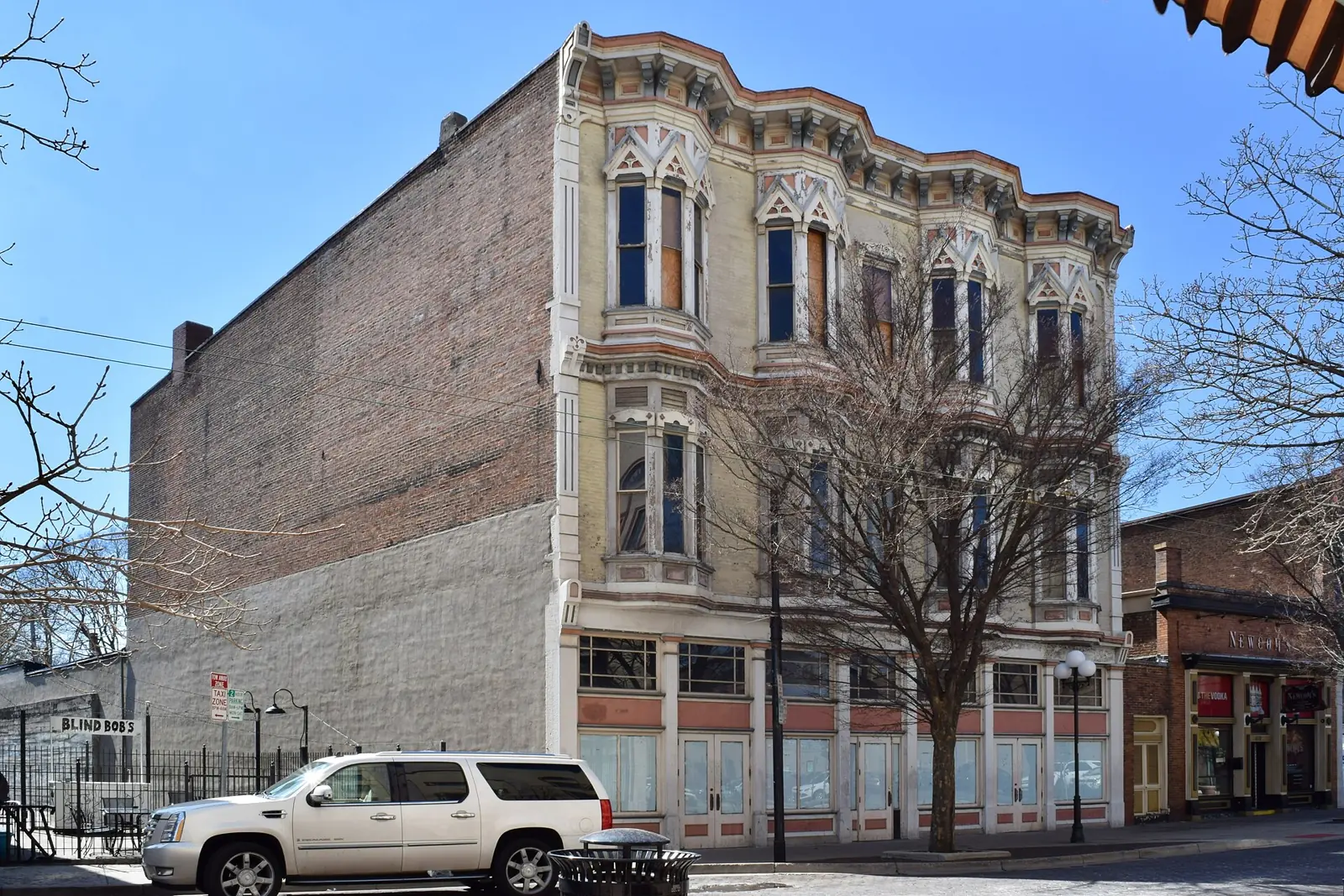 The Balsley Block, a 19th-century brick building with ornate window hoods in Dayton's Oregon District, under a blue sky