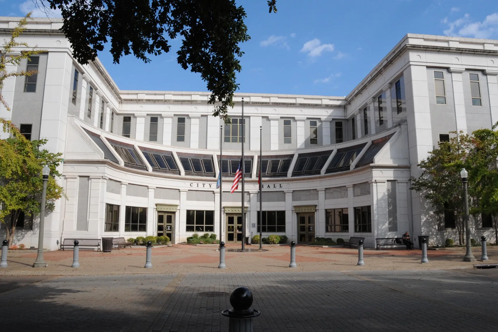 Curved white stone facade of Jackson City Hall on East Main Street in downtown Jackson, Tennessee, under a blue sky