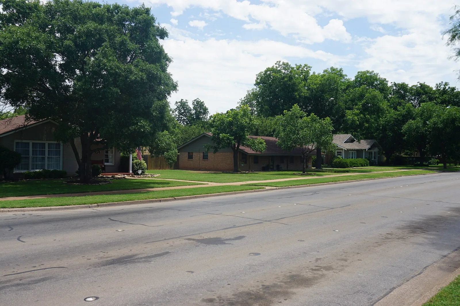 Brick ranch houses under shade trees along Sayles Boulevard in Abilene's Sayles Boulevard Historic District