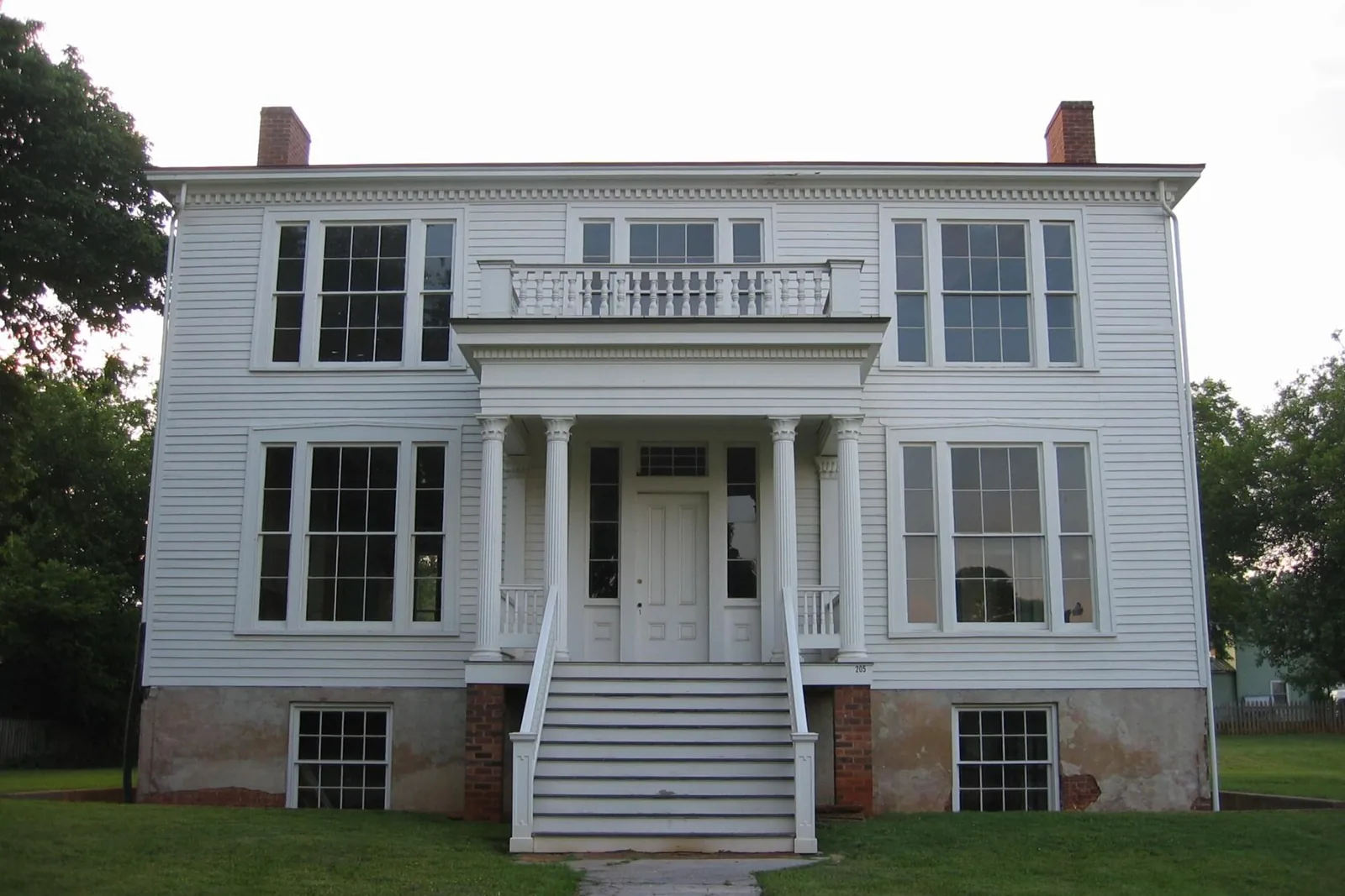 A white two-story frame house with a columned entry porch and balcony on Rivermont Avenue in Lynchburg