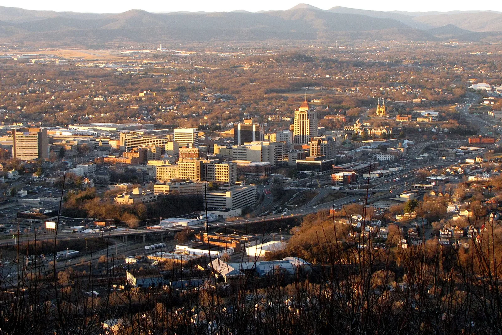 Downtown Roanoke and the Roanoke Valley seen from Mill Mountain in late afternoon light, with mountains beyond