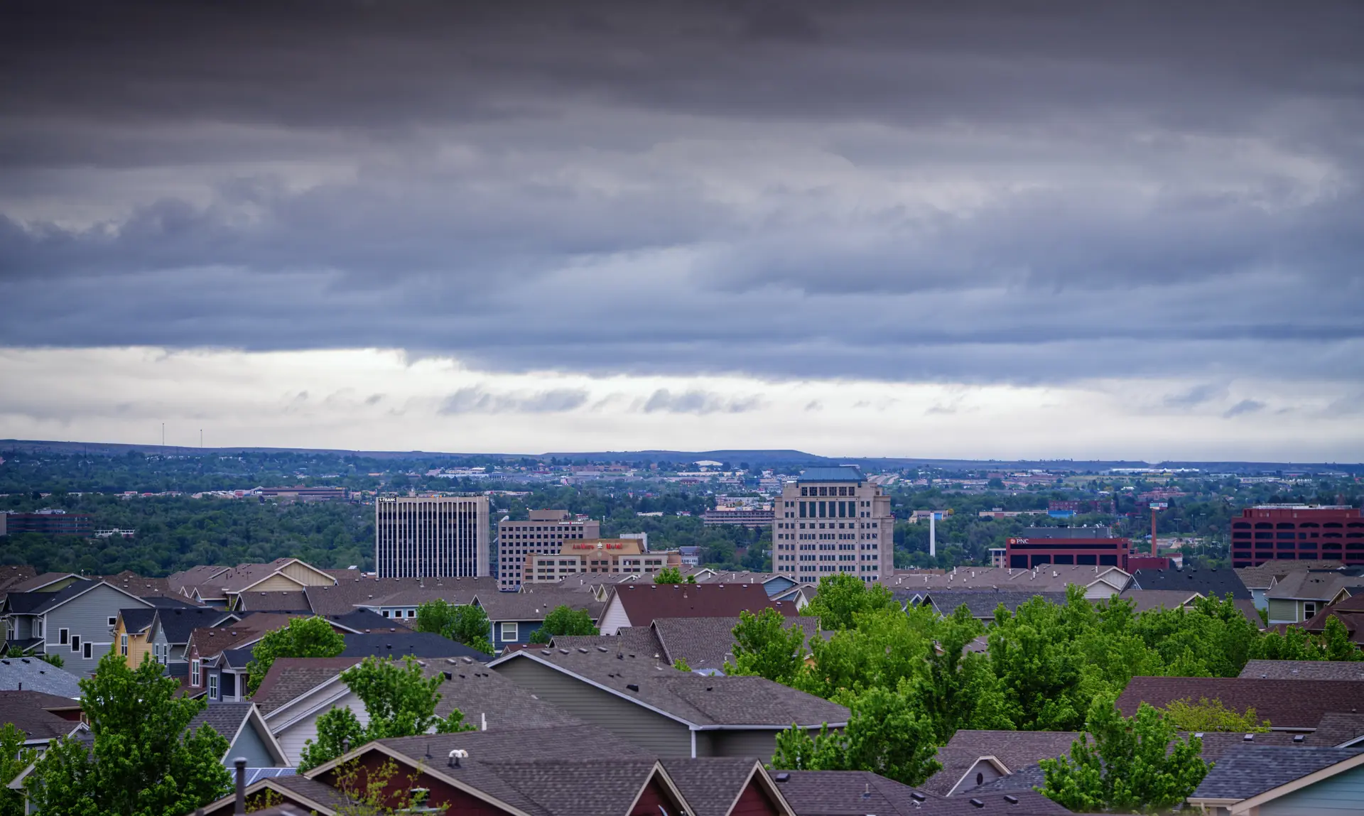 A view across Colorado Springs rooftops toward the Front Range foothills