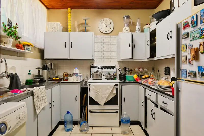 A small kitchen crowded with belongings on every surface