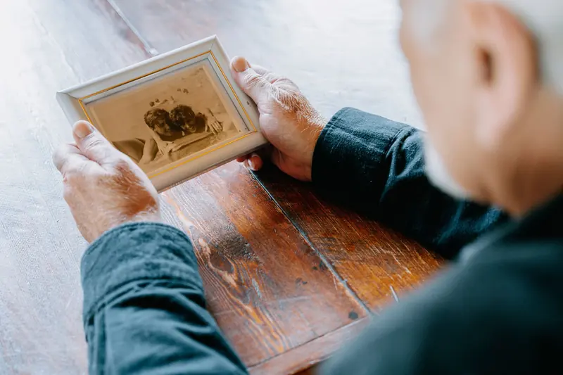 Hands holding an old framed family photograph