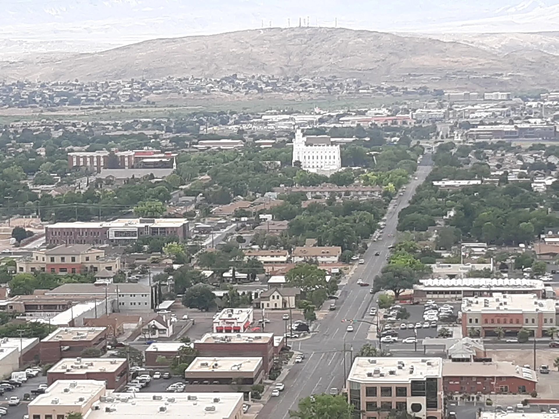 Downtown St. George, Utah from the Dixie Rock overlook, with the white St. George Temple among the tree-lined blocks and the mesa behind the city
